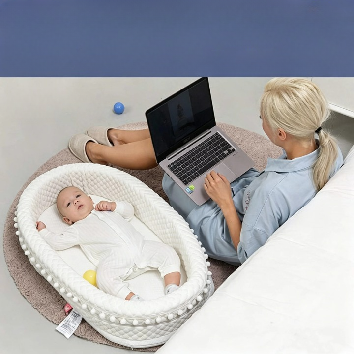 Réducteur de lit bébé allongé, maman travaille 
